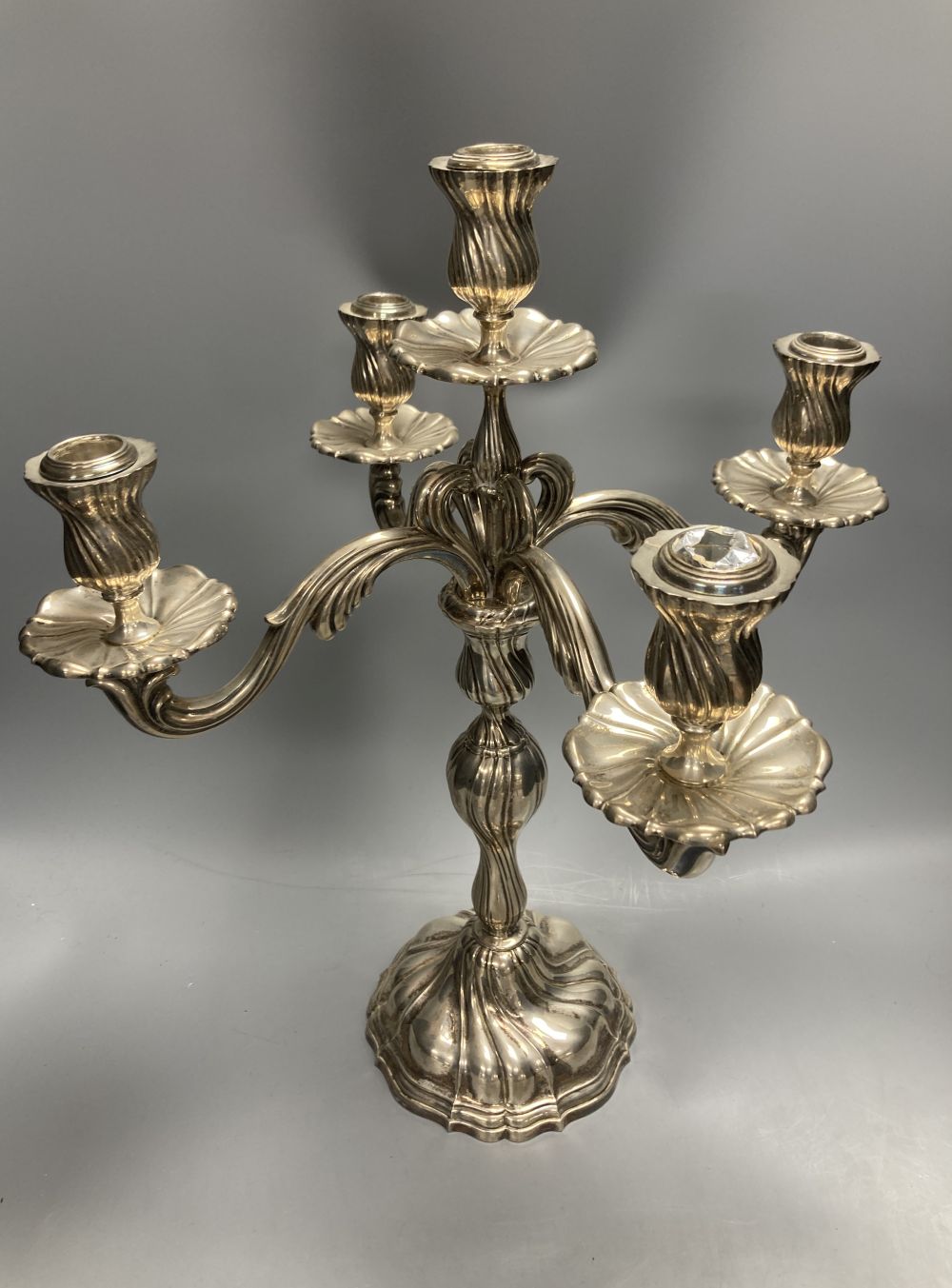 An early 20th century continental 830 white metal four branch, five light candelabrum,